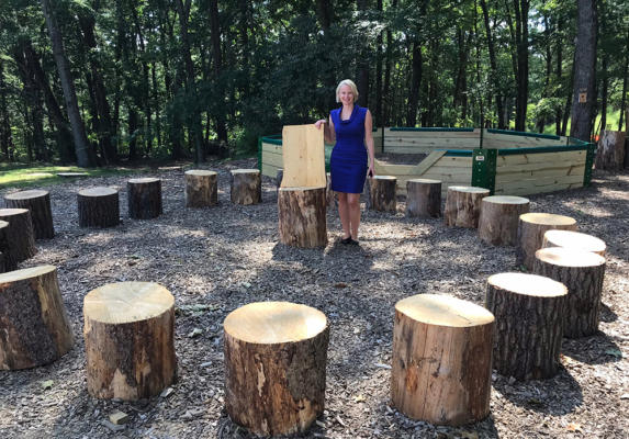 Wardell in the outdoor classroom with tree stumps for seats.