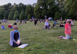 Residents stand and kneel in silence with their candles and lights. (Photo by Alice Waugh)